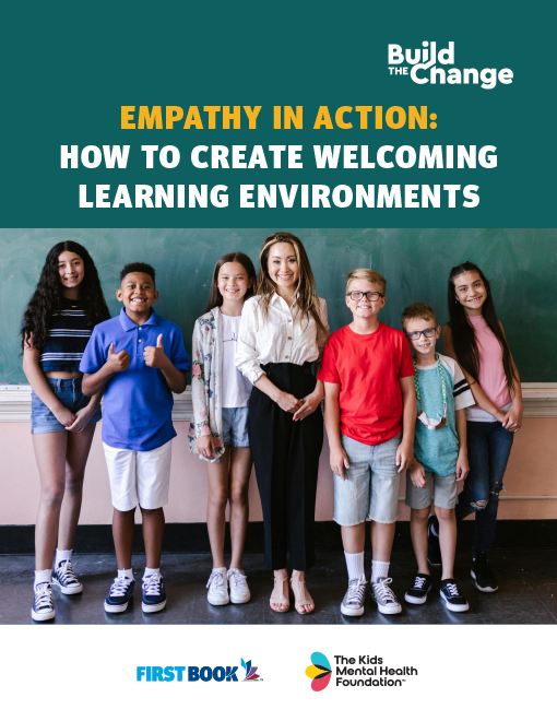 Cover of 'Empathy in Action: How to Create Welcoming Learning Environments,' a collaborative resource by First Book and The Kids Mental Health Foundation. Features a smiling teacher with diverse students standing in front of a chalkboard.